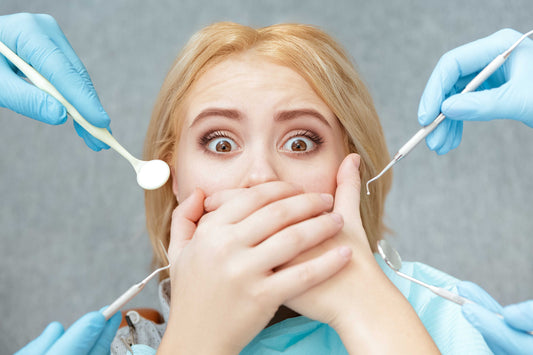Woman covering mouth with hands from dentist in fear, for AutoBrush blog
