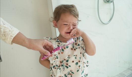 Child crying at traditional toothbrush, for AutoBrush blog