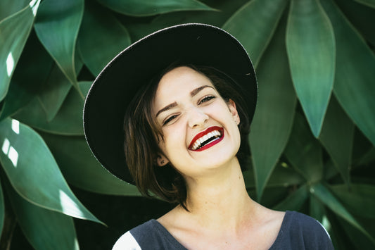 Woman wearing hat smiling with leaves on her background, for AutorBrush