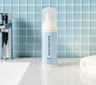 Autobrush mint toothpaste tube on a bathroom counter with a tiled wall background. #foamtoothpaste