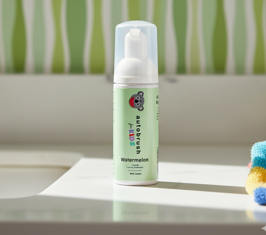 Green bottle of watermelon toothpaste on a white surface. #foamtoothpaste