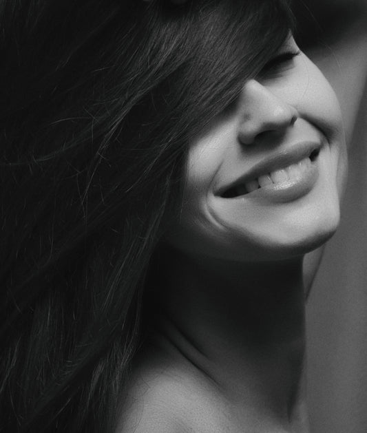 Black and white image of a woman smiling, for Autobrush