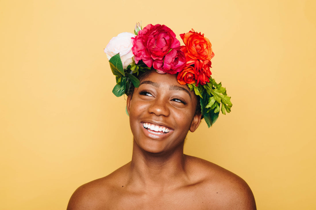 A woman smiling with flower headdress on yellow background, for AutoBrush