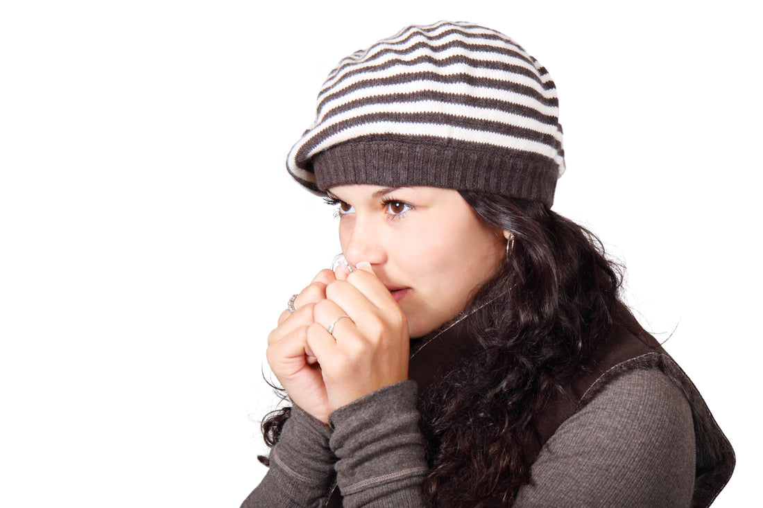 Woman wearing a beanie with her hands close to her mouth, for AutoBrush