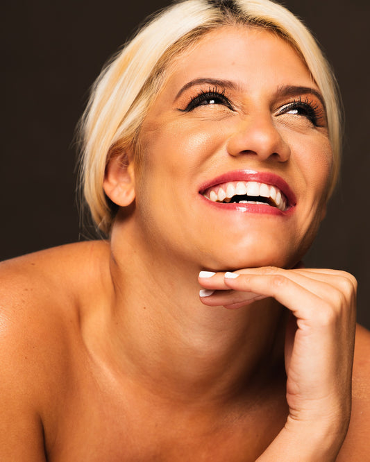 Blonde woman smiling while looking upward, for Autobrush