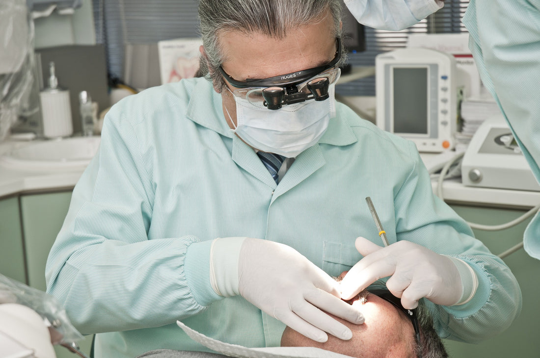 Dentist wearing goggles operating on patient, for AutoBrush