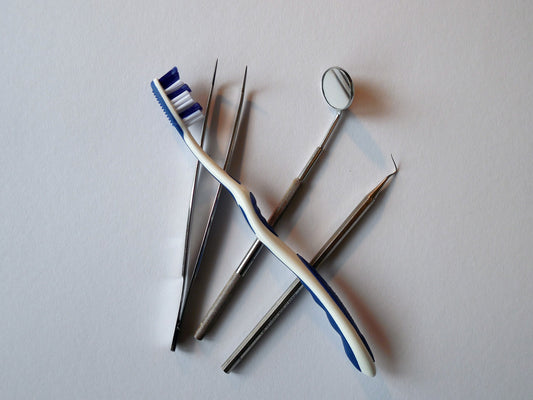 Image of a toothbrush on top of dentist tools, for AutoBrush