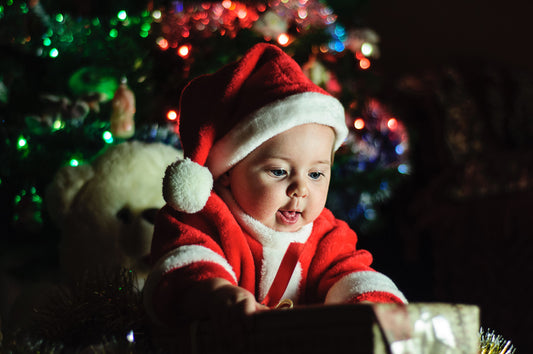 Toddler in a santa costume opening a present, for AutoBrush