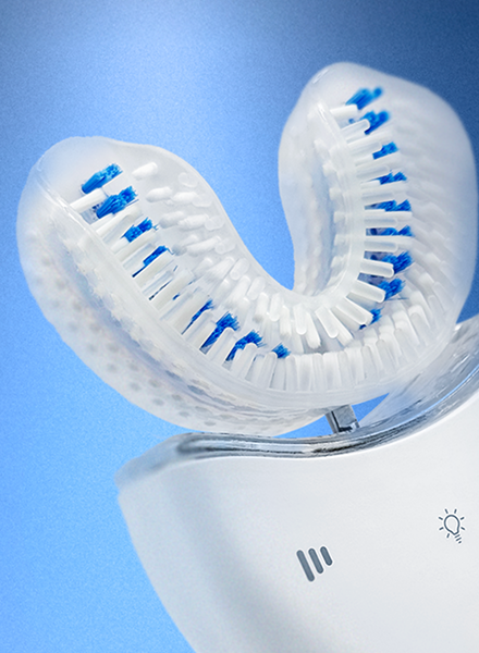 White electric U-toothbrush device with blue bristles on a blue background