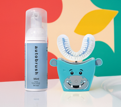 Automated toothbrush and bottle of autobrush mint against a colorful abstract background #sonicprokidsbundle